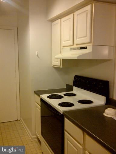 5907L Kingsford Road, Unit 402 Springfield, VA 22152 - Photo 4 of 8 a kitchen with a sink cabinets and a refrigerator