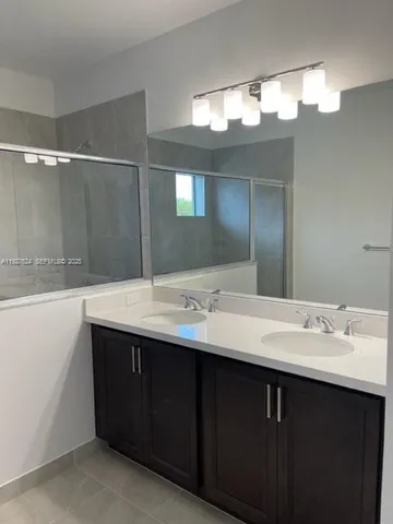 a bathroom with a double vanity sink and a mirror