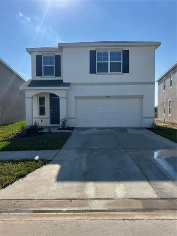 a front view of a house with garage and plants
