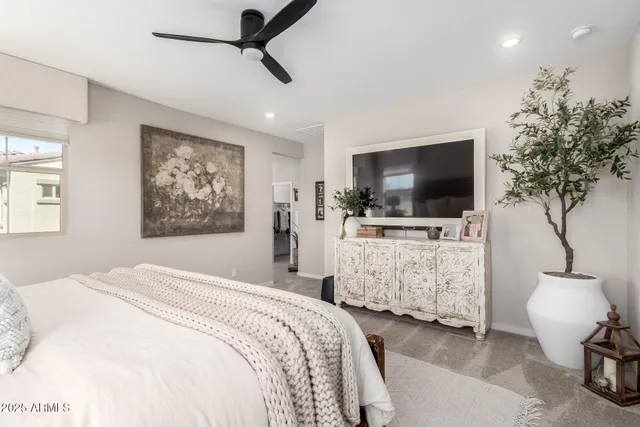 a bedroom with bed and tv with potted plants