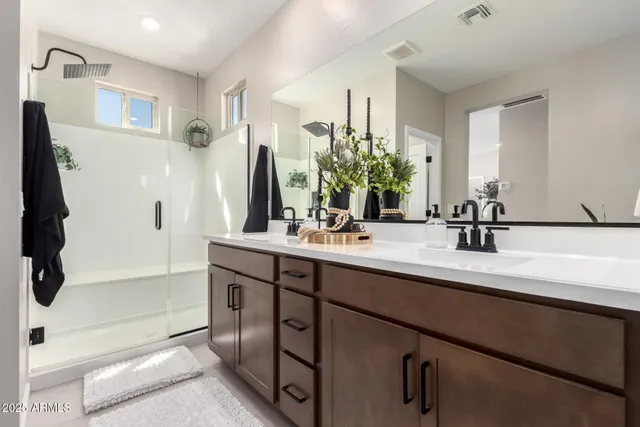 a bathroom with a double vanity sink a mirror and a bathtub