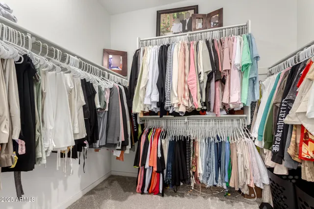 a view of walk in closet with clothes