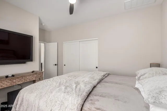 a bedroom with a bed and a flat screen tv