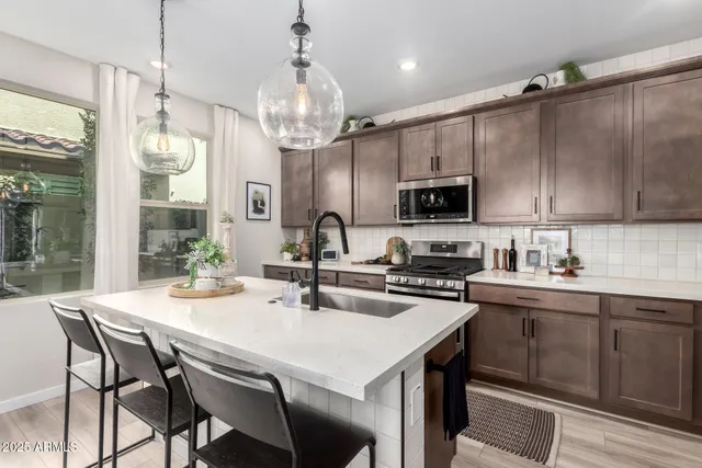 a kitchen with sink a microwave and cabinets