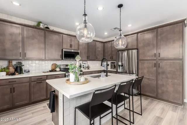 a kitchen with refrigerator cabinets dining table and chairs