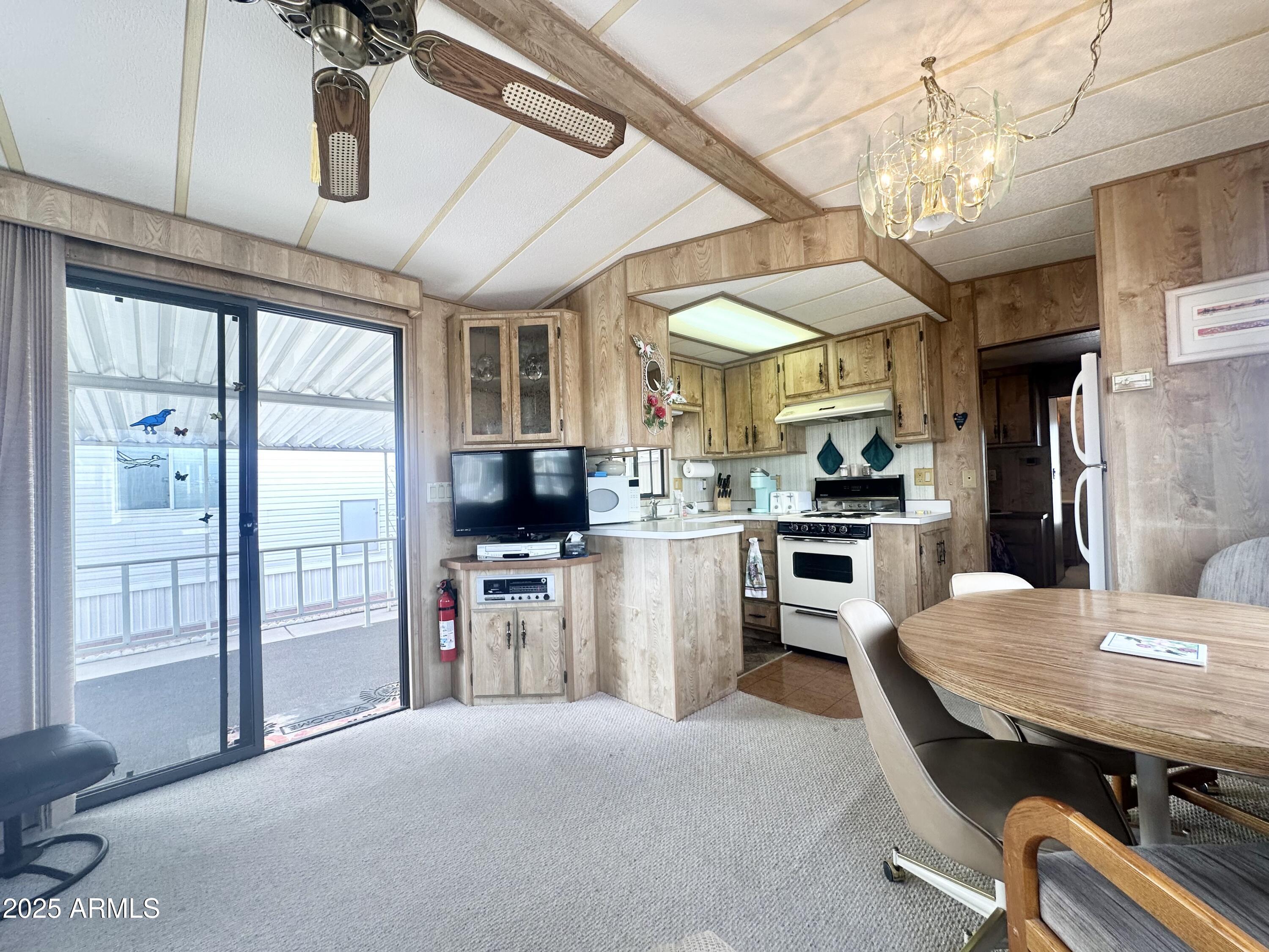 3710 South Goldfield Road, Unit 1052 Apache Junction, AZ 85119 - Photo 16 of 48 a kitchen with refrigerator a stove and chairs