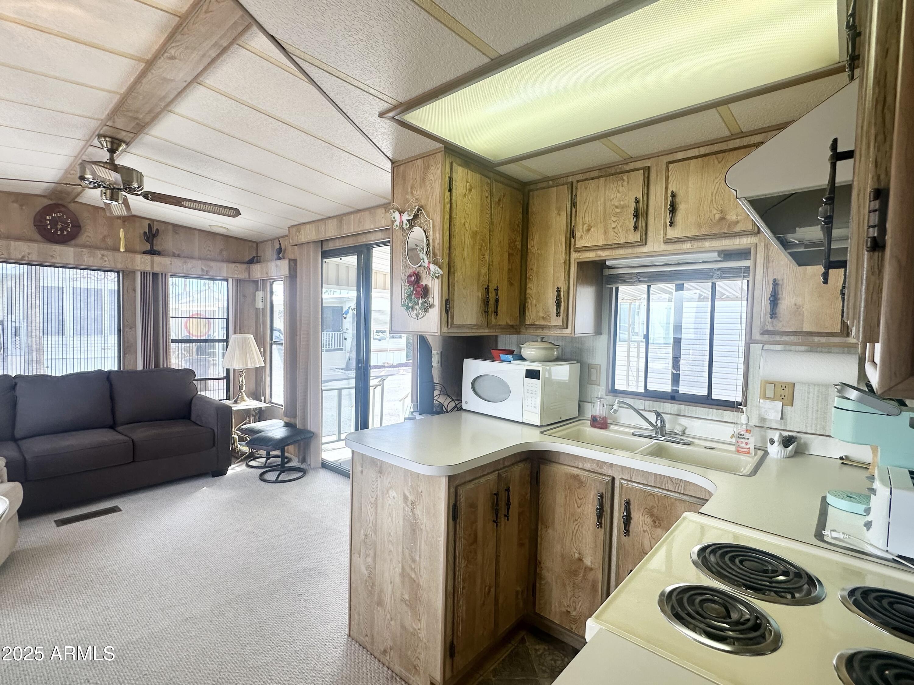 3710 South Goldfield Road, Unit 1052 Apache Junction, AZ 85119 - Photo 17 of 48 a kitchen with a sink appliances cabinets and a large window