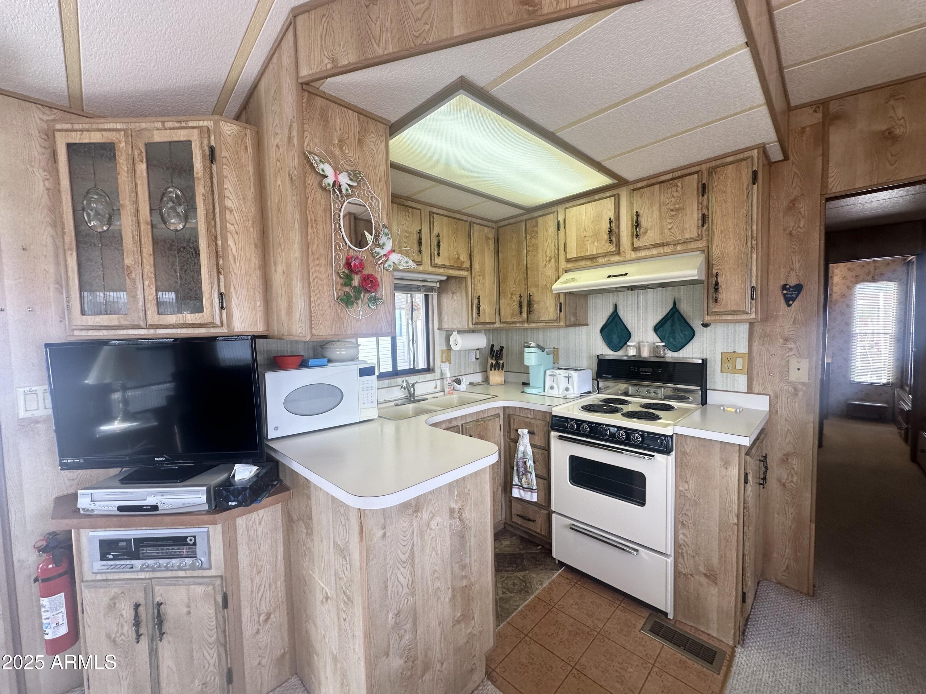 3710 South Goldfield Road, Unit 1052 Apache Junction, AZ 85119 - Photo 19 of 48 a kitchen with a stove and a sink