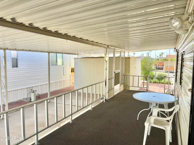a view of a white house with large windows and a small yard