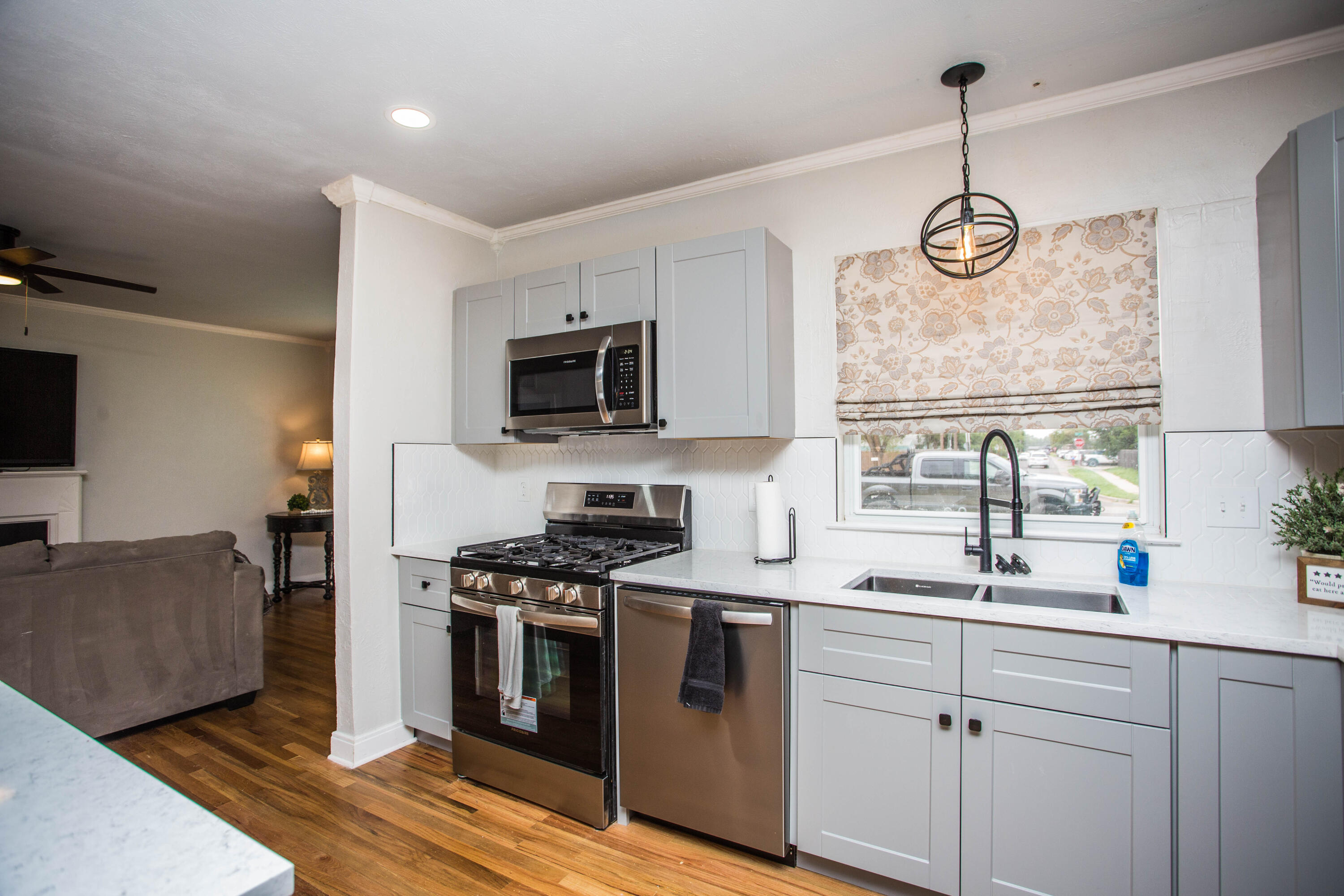 2712 30th Street Lubbock, TX 79410 - Photo 5 of 26 a kitchen with stainless steel appliances a stove a sink and white cabinets