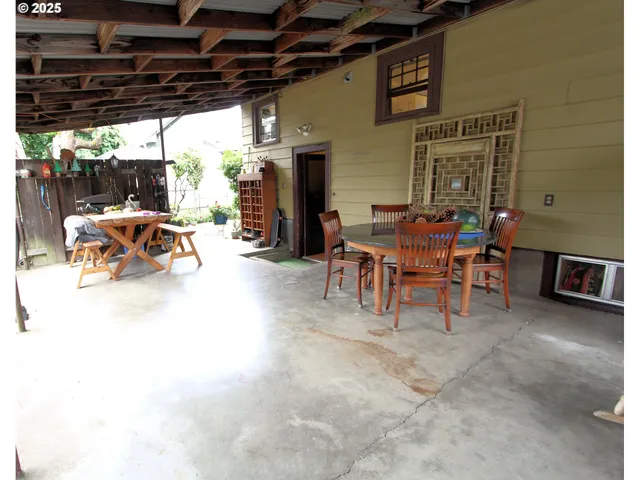 a view of a table and chairs under an umbrella in backyard