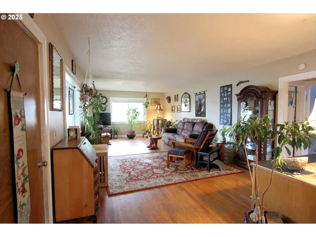 a living room with furniture potted plant and a refrigerator