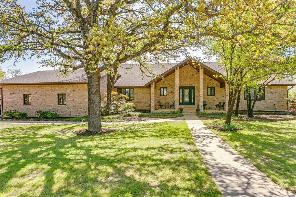 1557 Latigo Hills Road Bartonville, TX 75022 - Photo 1 of 40 View of front of property featuring covered porch, brick siding, a front lawn, and a shingled roof