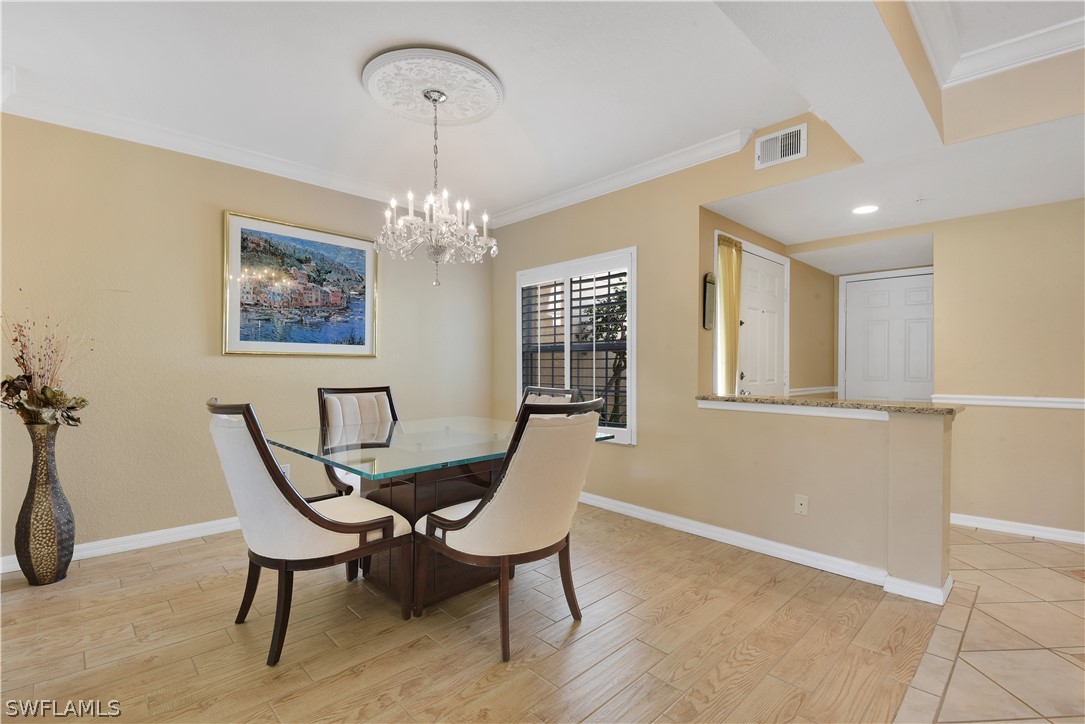 6838 Lantana Bridge Road, Unit 102 Naples, FL 34109 - Photo 12 of 34 a view of a dining room with furniture and chandelier