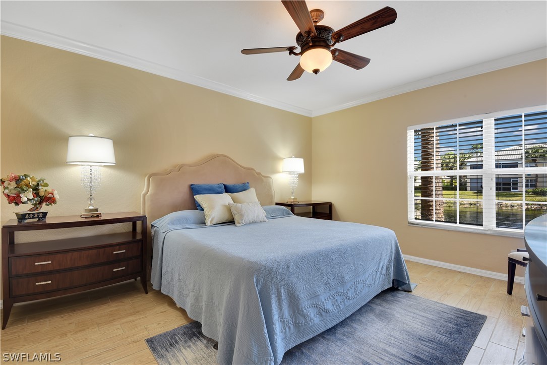 6838 Lantana Bridge Road, Unit 102 Naples, FL 34109 - Photo 15 of 34 a bedroom with a bed and wooden floor