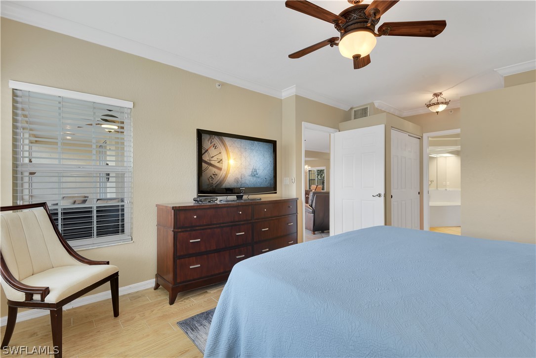 6838 Lantana Bridge Road, Unit 102 Naples, FL 34109 - Photo 16 of 34 a bedroom with a bed and a chandelier