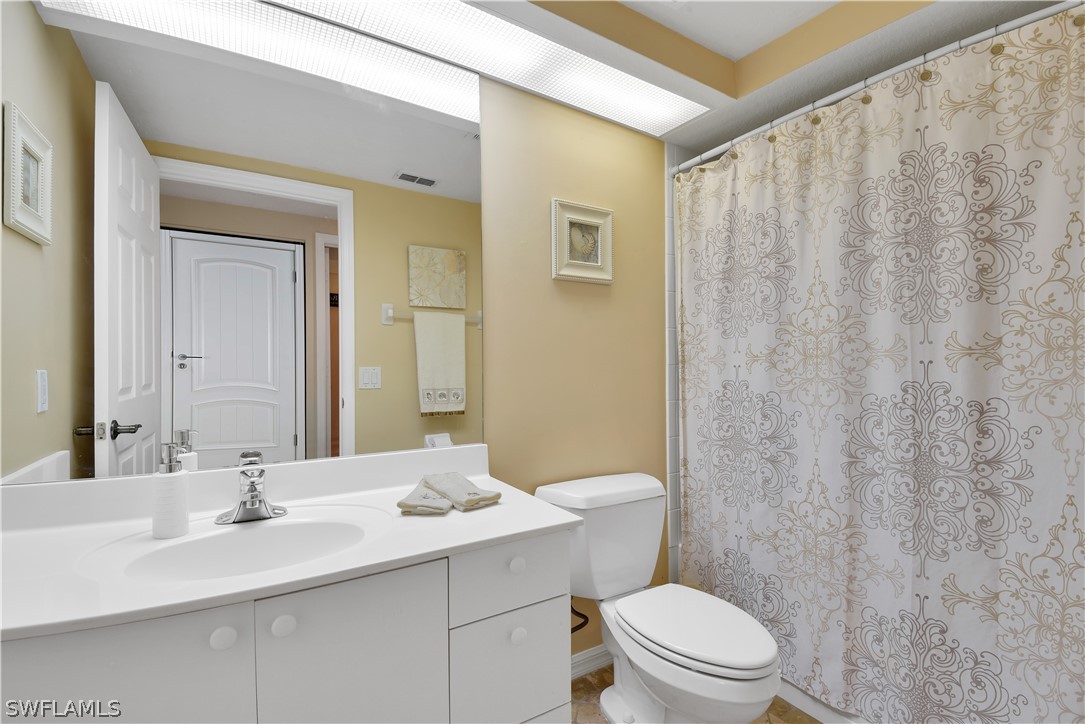 6838 Lantana Bridge Road, Unit 102 Naples, FL 34109 - Photo 21 of 34 a bathroom with a sink a toilet and shower curtain