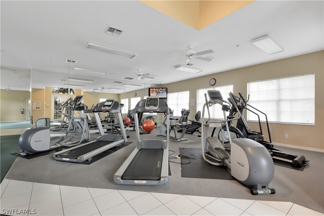6838 Lantana Bridge Road, Unit 102 Naples, FL 34109 - Photo 28 of 34 a room with gym equipment and large mirror
