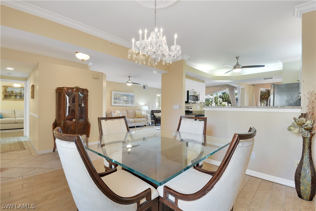 6838 Lantana Bridge Road, Unit 102 Naples, FL 34109 - Photo 5 of 34 a dining room with furniture and chandelier