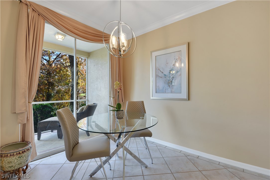 6838 Lantana Bridge Road, Unit 102 Naples, FL 34109 - Photo 10 of 34 a view of a dining room with furniture wooden floor and chandelier