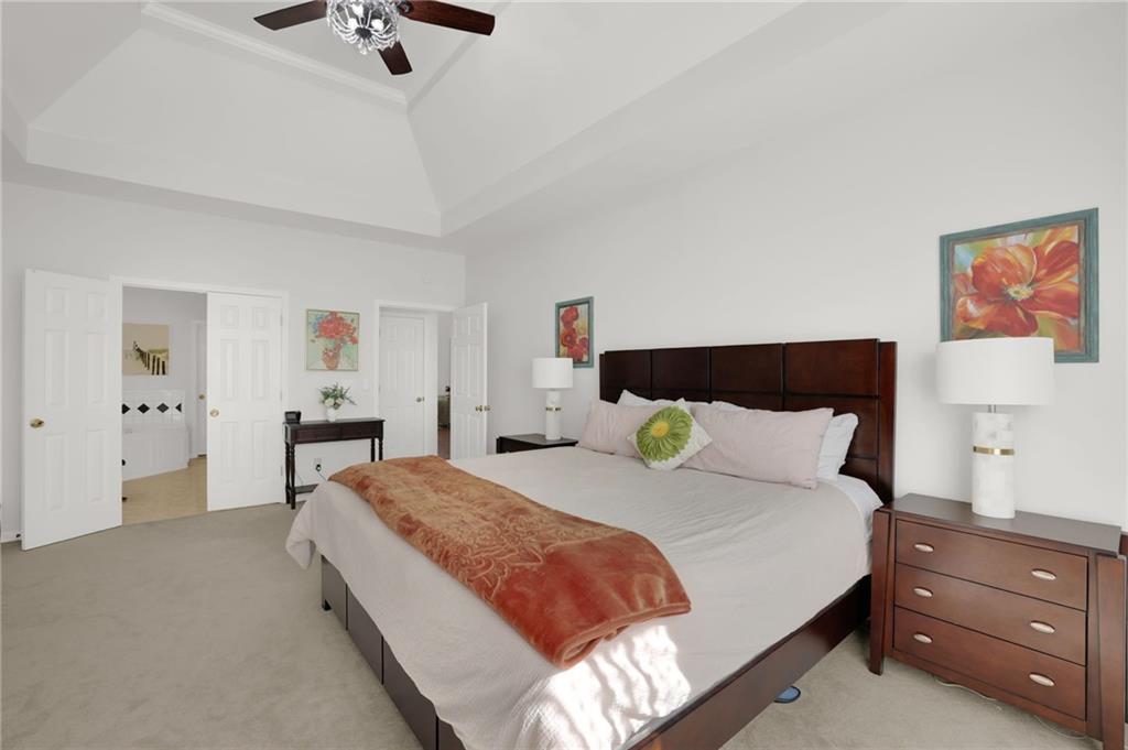 520 Ruby Forest Parkway Suwanee, GA 30024 - Photo 15 of 37 a bedroom with a bed and a chandelier