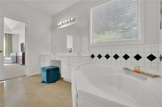 a bathroom with a bathtub sink and mirror