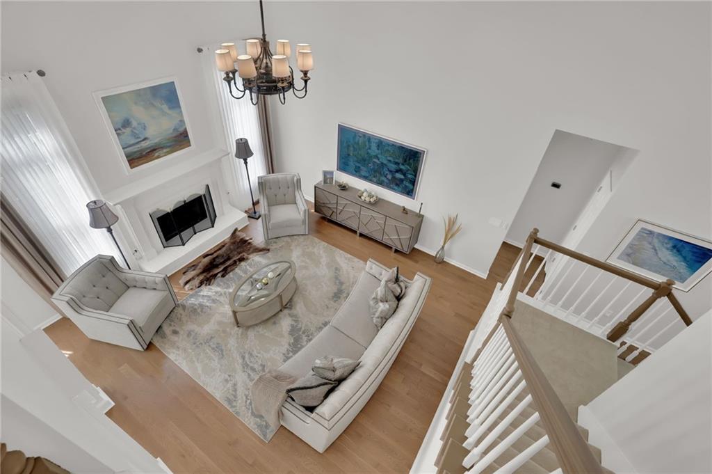 520 Ruby Forest Parkway Suwanee, GA 30024 - Photo 19 of 37 a living room with furniture a fireplace and a chandelier