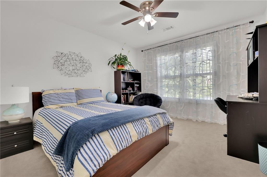 520 Ruby Forest Parkway Suwanee, GA 30024 - Photo 22 of 37 a bedroom with a large bed and a flat tv screen on dresser
