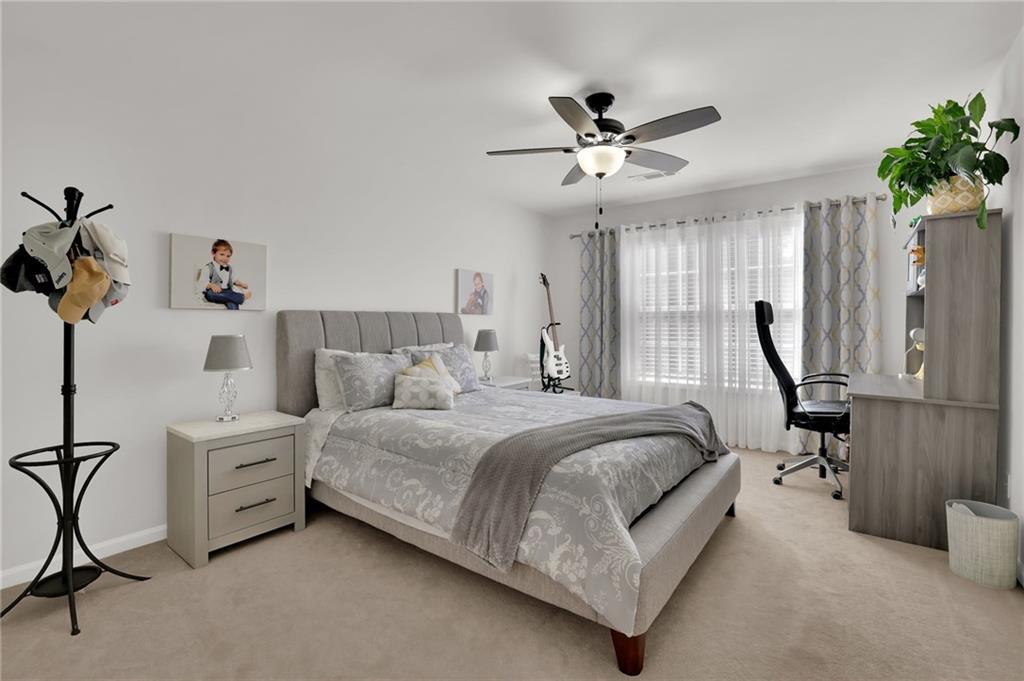 520 Ruby Forest Parkway Suwanee, GA 30024 - Photo 23 of 37 a spacious bedroom with a bed and a chandelier