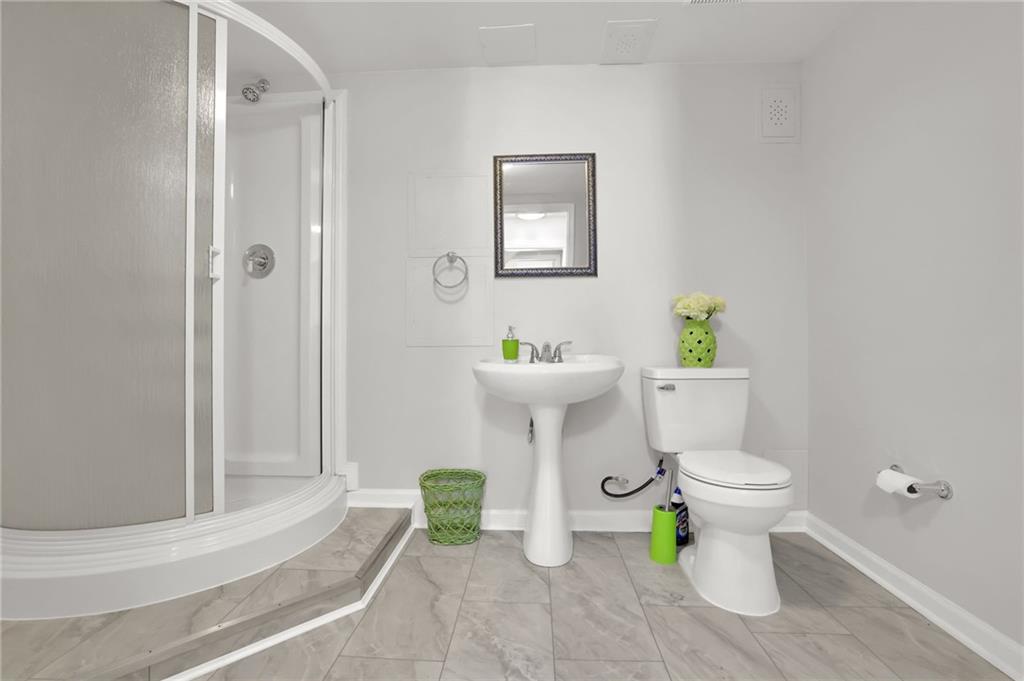 520 Ruby Forest Parkway Suwanee, GA 30024 - Photo 31 of 37 a white toilet sitting next to a bathroom sink and a shower