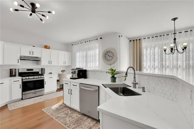 a kitchen with a sink a stove and cabinets