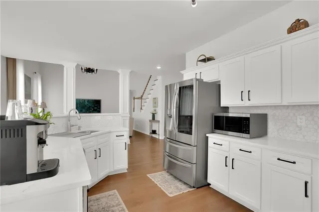 a kitchen with white cabinets and stainless steel appliances