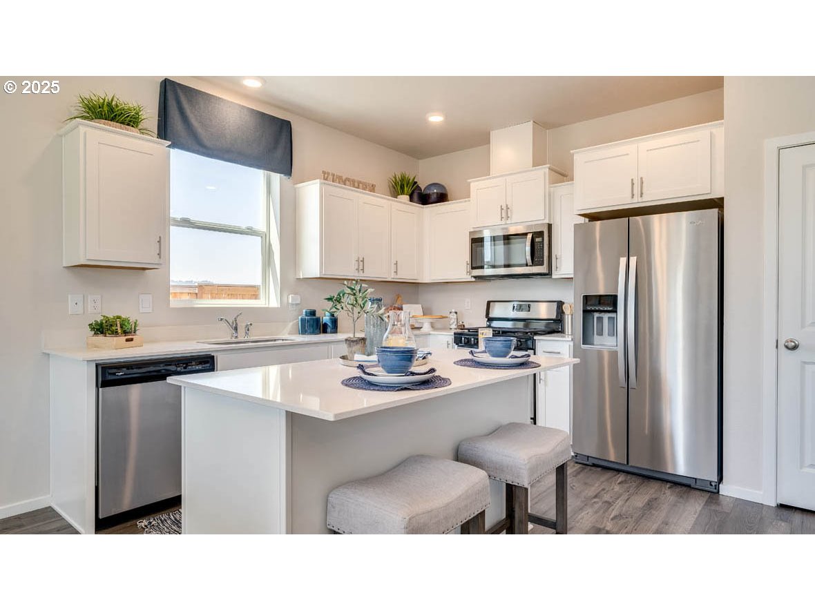 2343 30th Place Springfield, OR 97477 - Photo 10 of 29 a kitchen with stainless steel appliances a sink a stove a refrigerator a counter top space and cabinets