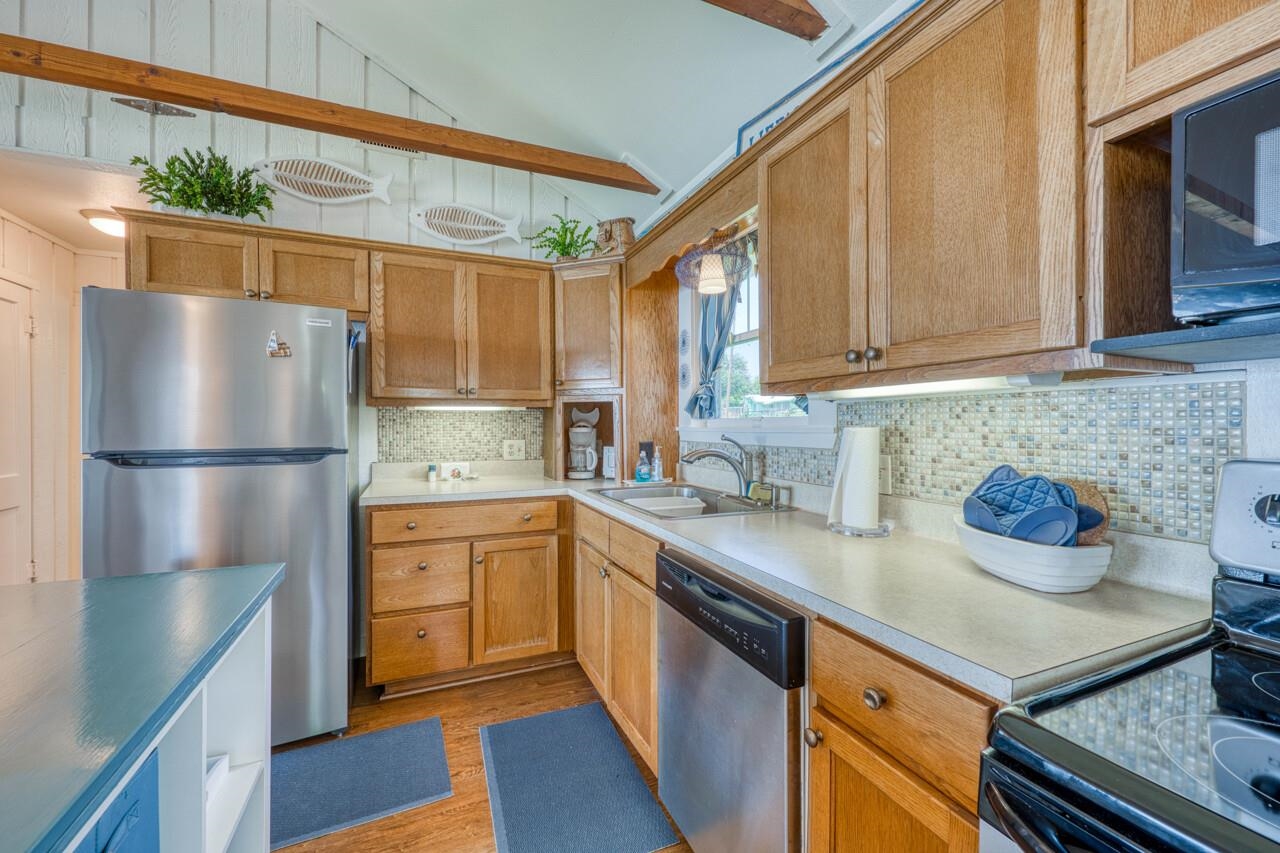 809 Lakeshore Loop Tow, TX 78672 - Photo 10 of 33 a kitchen with a sink a refrigerator and cabinets
