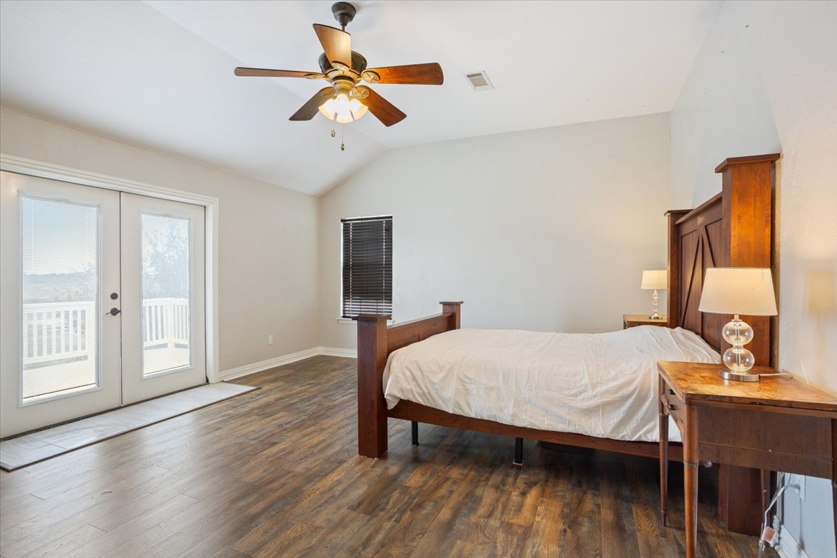 8600 Five Wells Road Rogers, TX 76569 - Photo 16 of 40 Bedroom featuring lofted ceiling, french doors, dark wood-style flooring, access to exterior, and a ceiling fan
