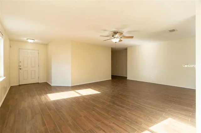 a view of a room with wooden floor and fan