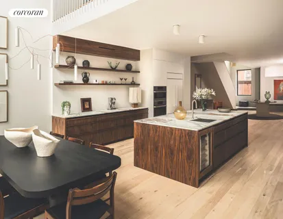 a kitchen with a stove a sink a refrigerator and a dining table with wooden floor