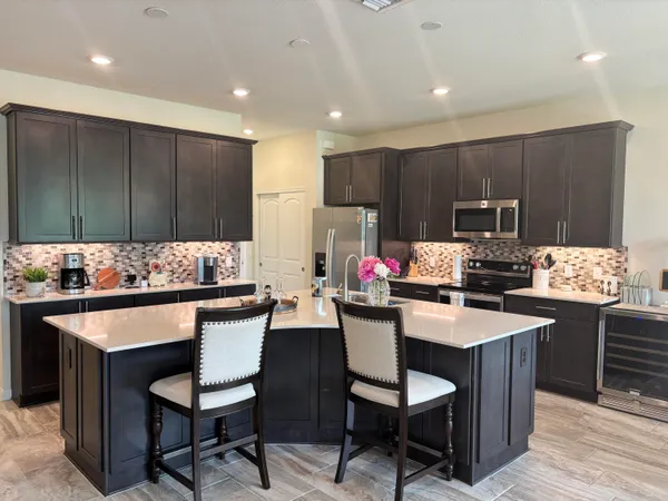 a kitchen with kitchen island granite countertop a sink counter and chairs