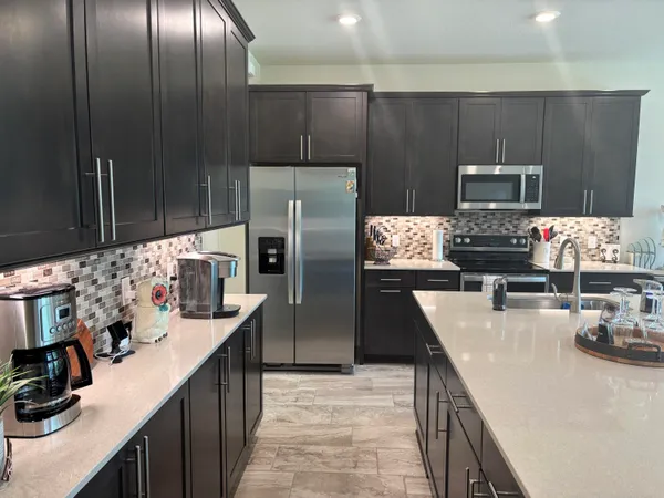 a kitchen with stainless steel appliances kitchen island granite countertop a refrigerator and a stove