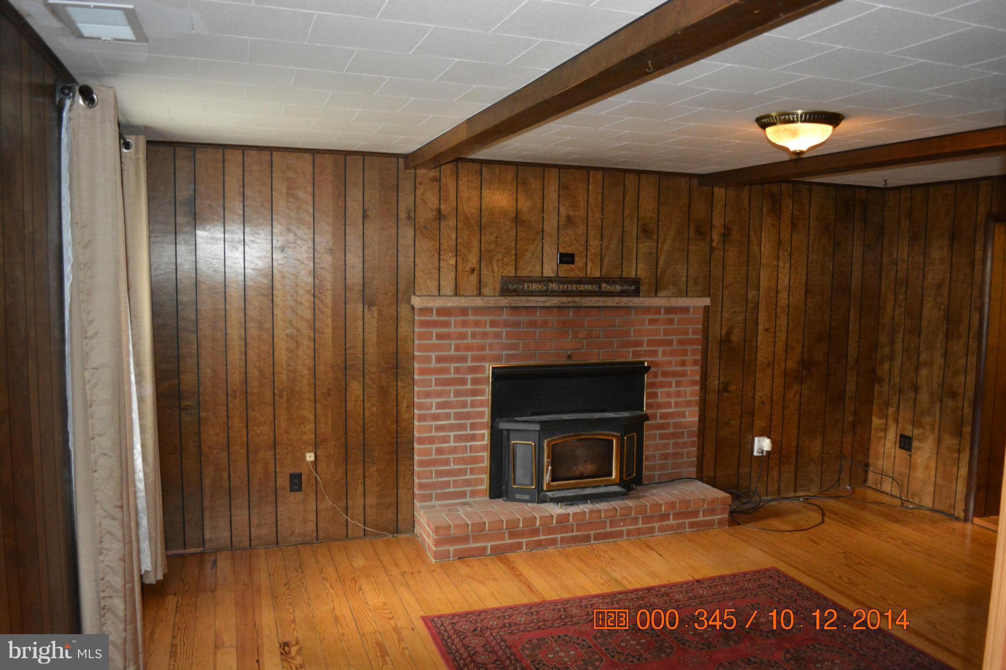 13106 Mercersburg Road Clear Spring, MD 21722 - Photo 10 of 11 a view of an empty room with wooden floor a fireplace and a window