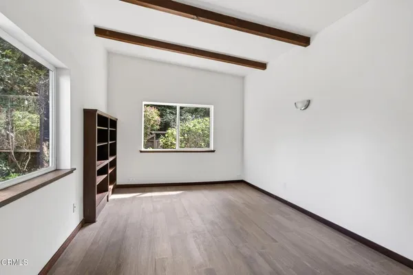 an empty room with wooden floor and a window