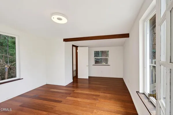 a view of a big room with wooden floor and windows