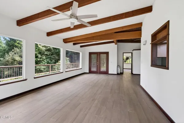 a view of livingroom with furniture wooden floor fan and windows