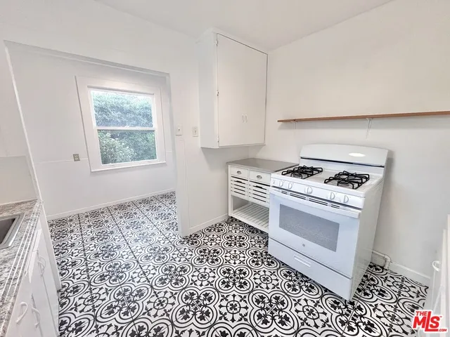 a kitchen with a stove a sink and a window