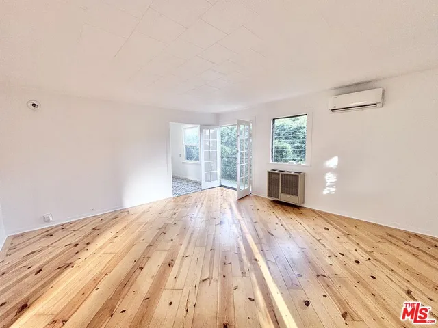 a view of empty room with wooden floor and fireplace