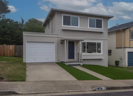 a front view of a house with a yard and a garage