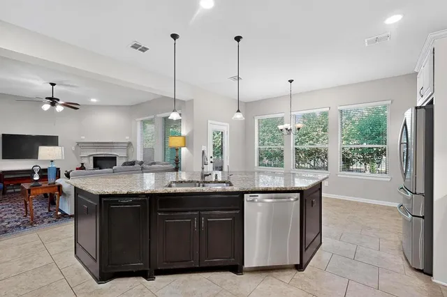 a dining hall with stainless steel appliances granite countertop a stove and a sink