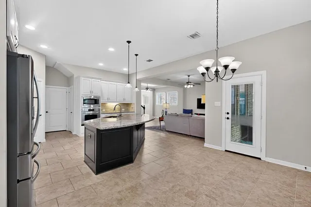a large kitchen with a table and refrigerator