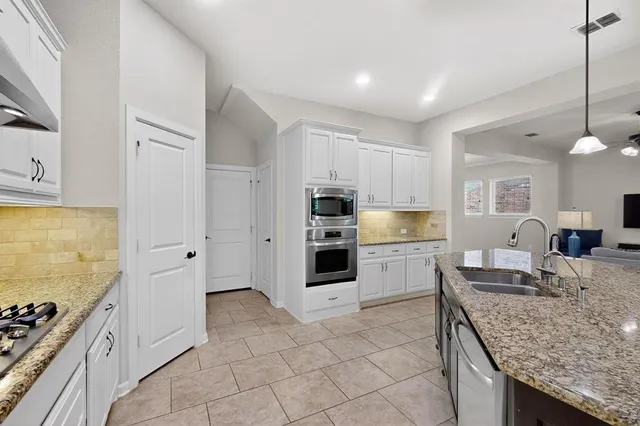 a kitchen with stainless steel appliances granite countertop a stove oven and a refrigerator