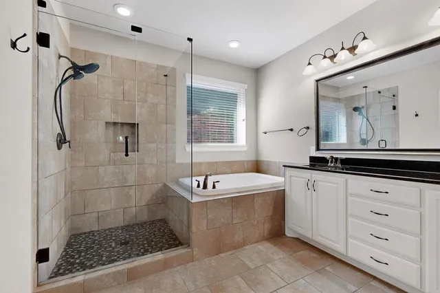 a bathroom with a tub a sink and a mirror